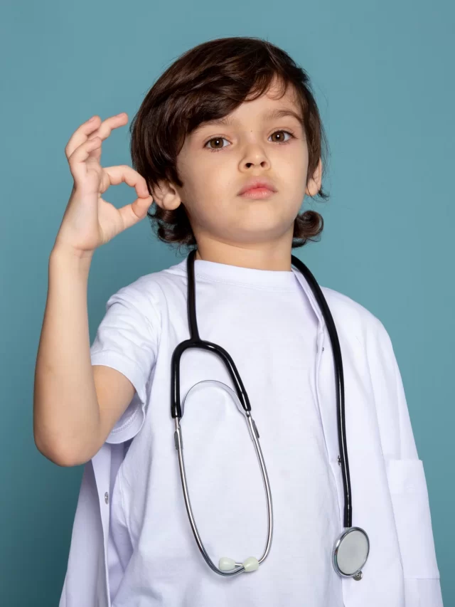 cute-little-child-boy-white-medical-suit-showing-sign-blue-wall